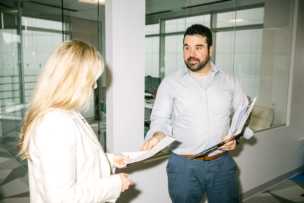 professional man handing woman paper