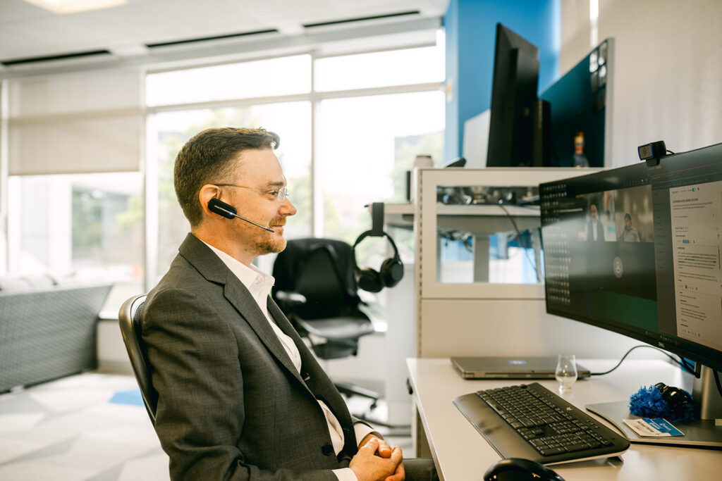 Charles IT tech with headset at computer in Stamford CT