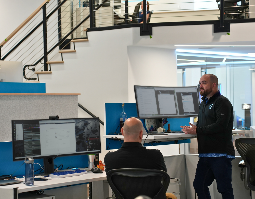 Charles IT professionals working together to solve a technology issue