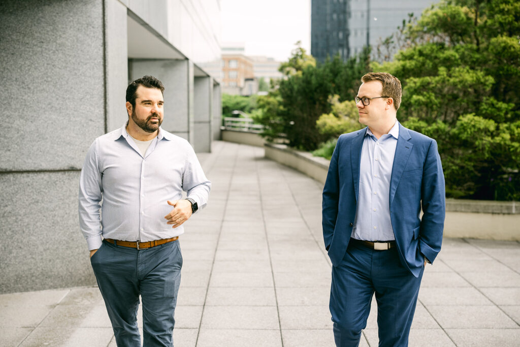 Two Charles IT professionals walking and talking outside an office