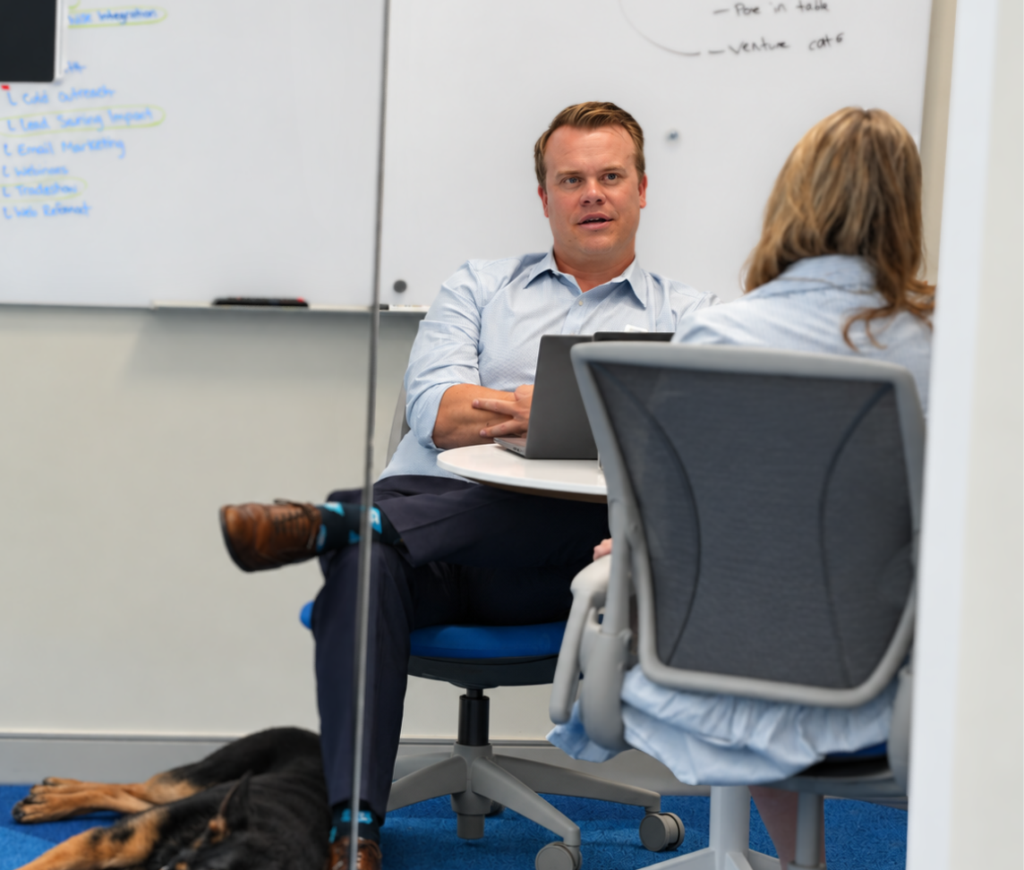 Business leaders meeting with cybersecurity experts to discuss risk management, compliance requirements, and operational resilience.