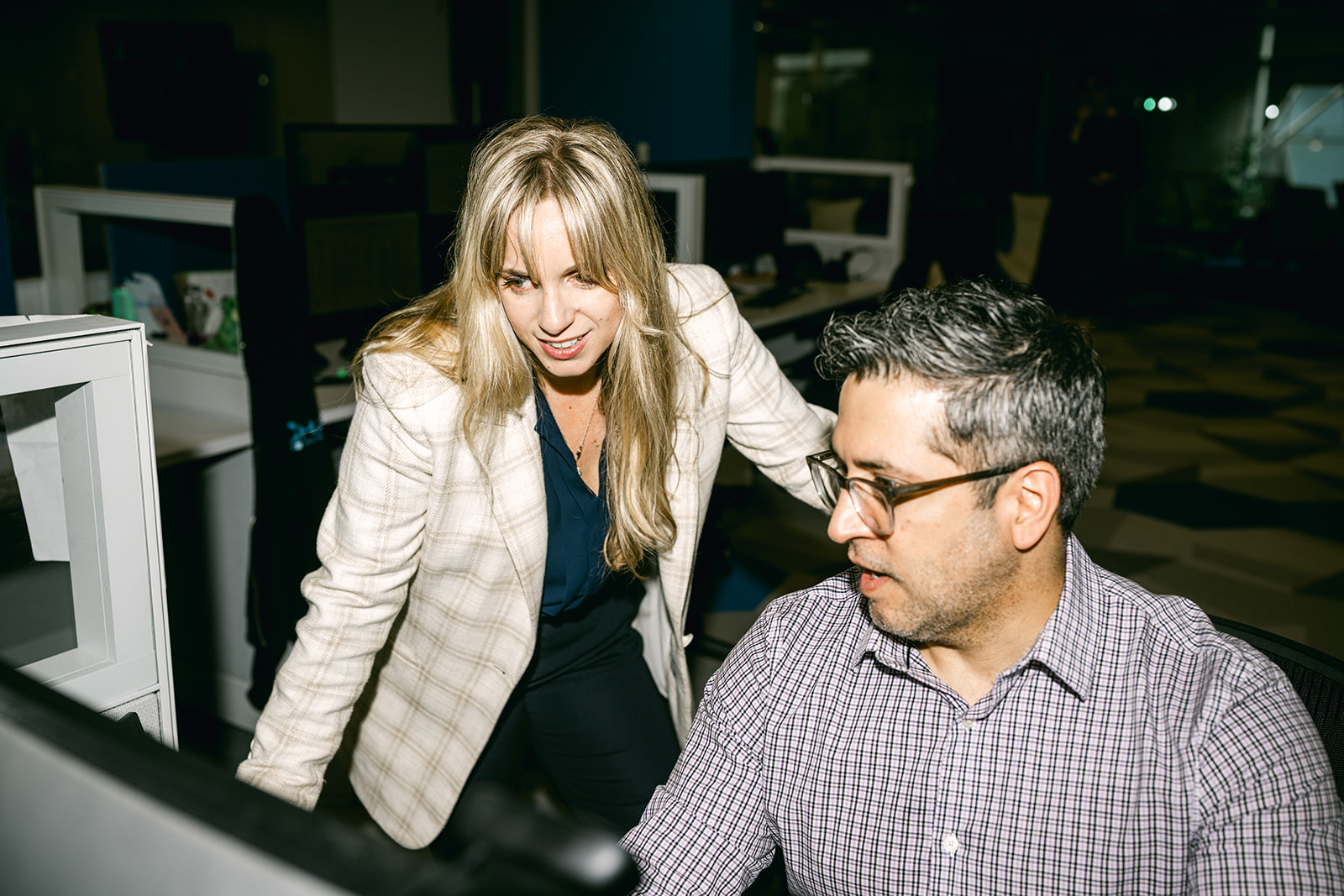 Two Charles IT team members collaborating at a workstation in a modern office environment.
