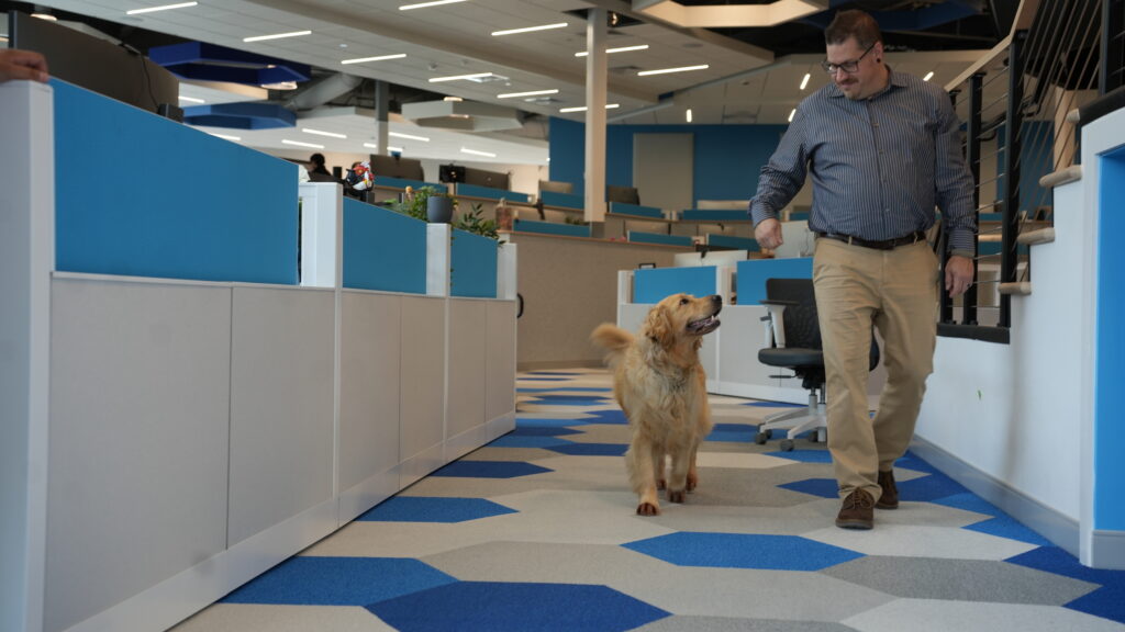 Team lead walking with his dog inside Charles IT headquarters, showcasing the company's employee-friendly office environment and workplace culture.